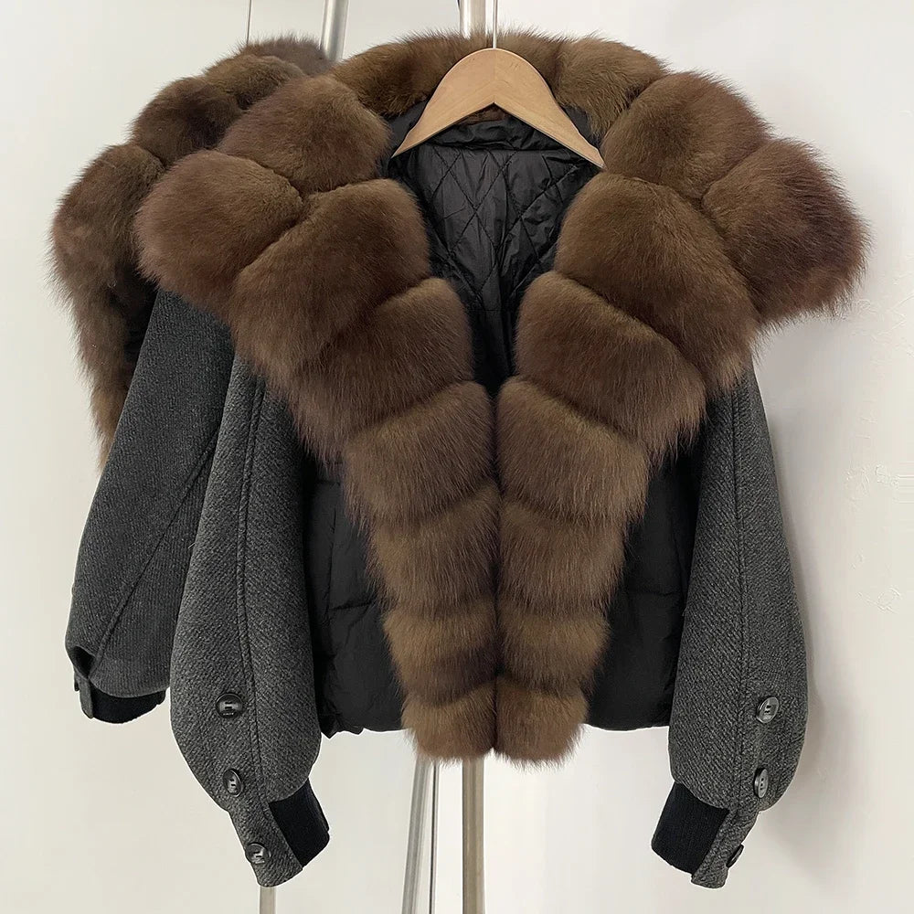 Gray coat with brown fur trim on a hanger against a white background