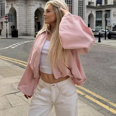 Woman wearing a pink balloon sleeve collared zip-front cropped jacket