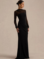 Woman wearing a black evening gown against a beige background