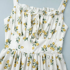 White dress with lemon print on a light blue background