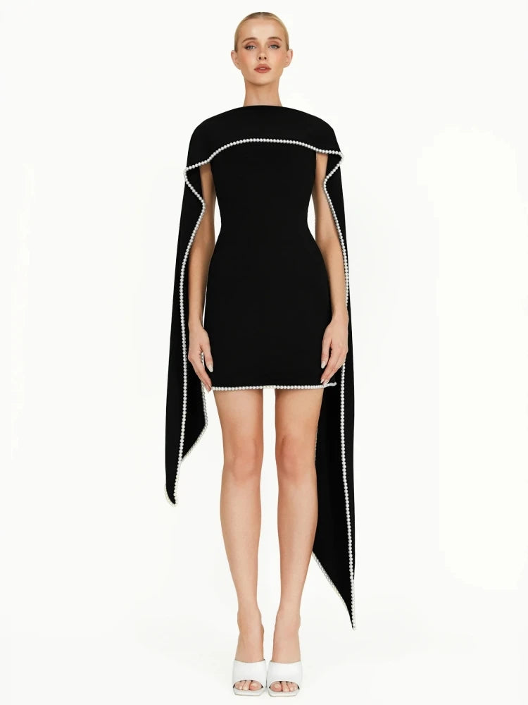 Black dress with white trim worn by a model on a white background