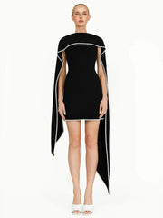 Black dress with white trim worn by a model on a white background