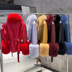 Collection of fur-trimmed jackets displayed on a rack against a gray wall.