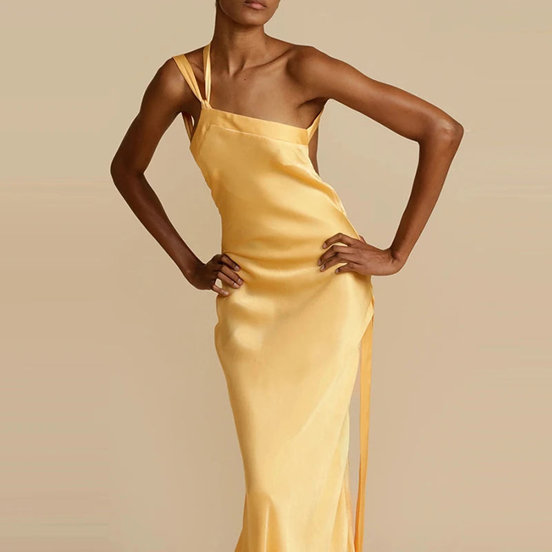 Woman wearing a yellow satin dress against a beige background