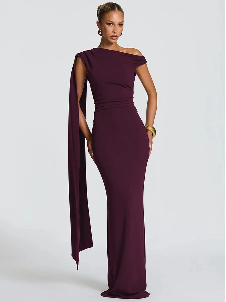 Woman wearing a burgundy one-shoulder gown on a light gray background