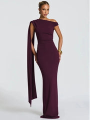 Woman wearing a burgundy one-shoulder gown on a light gray background