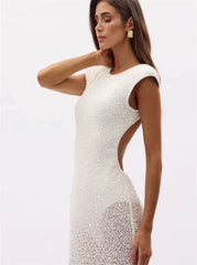 Side profile of a white sequined backless gown dress.