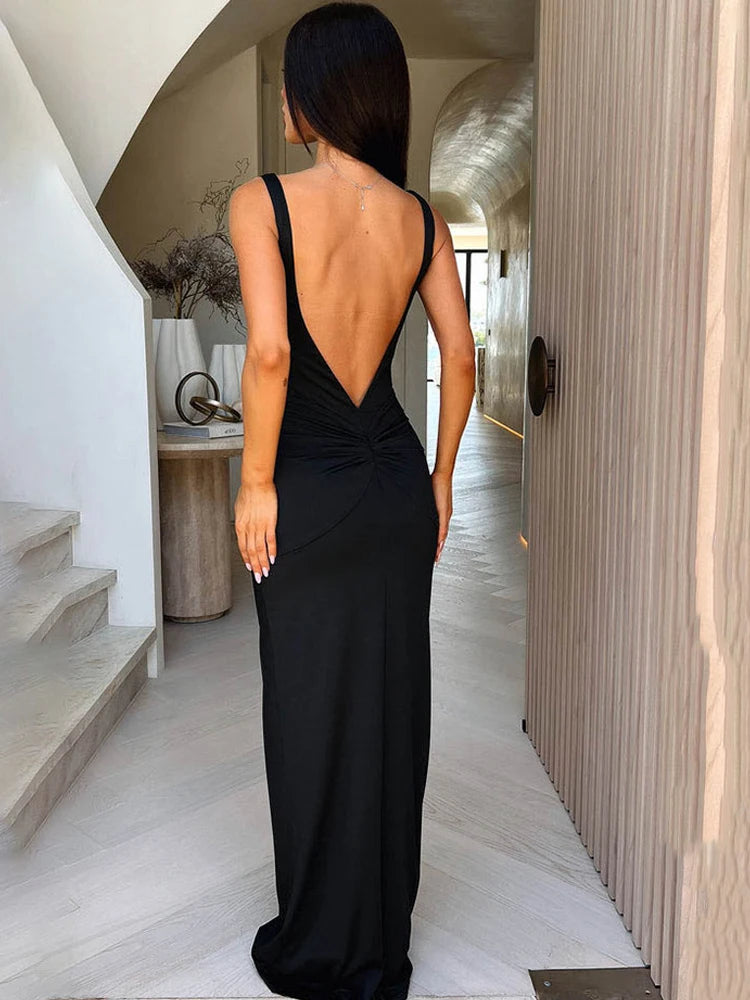 Woman in a black evening gown walking through a modern interior.