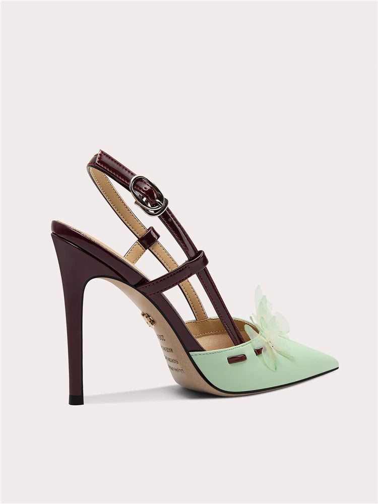 Mint green high-heeled shoe with a decorative bow on a light gray background