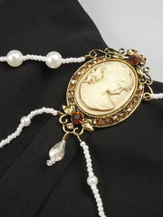 Decorative brooch with pearl chain on a black background