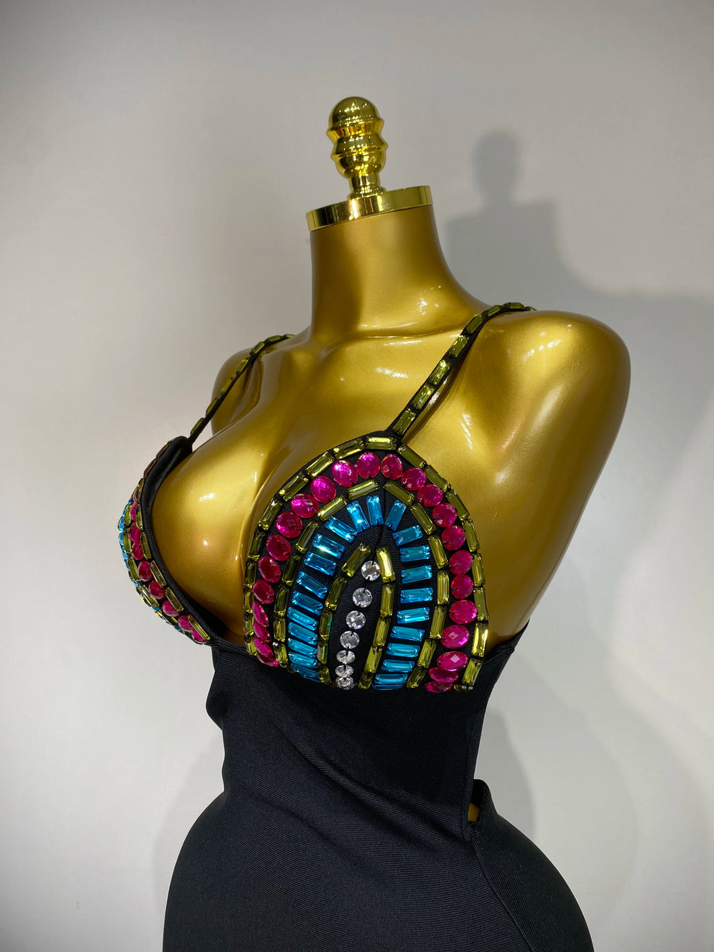 Mannequin wearing a colorful beaded top with a plain background