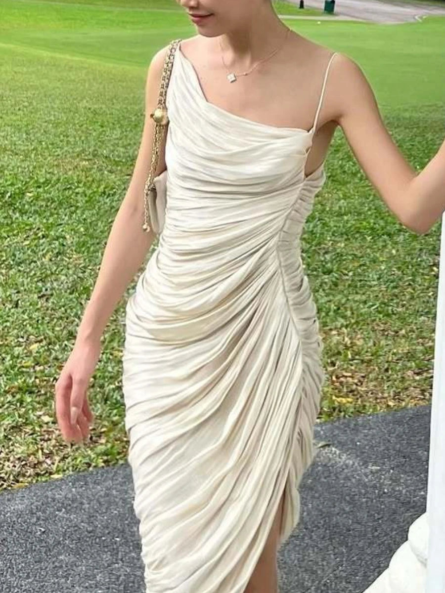 Woman wearing a white one-shoulder dress with a green grass background
