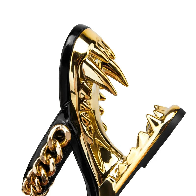 Gold and black high-heeled shoes with wing-like design on a white background
