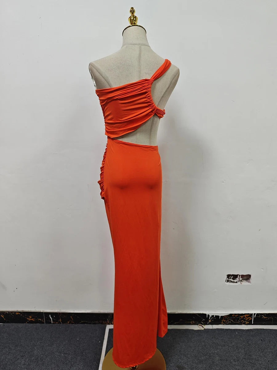 Orange evening gown on a mannequin against a white wall.