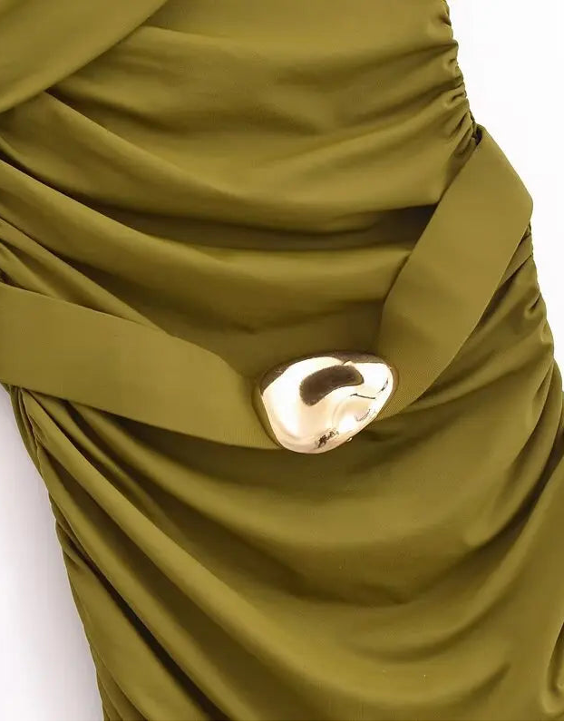 Close-up of a green dress with a gold button