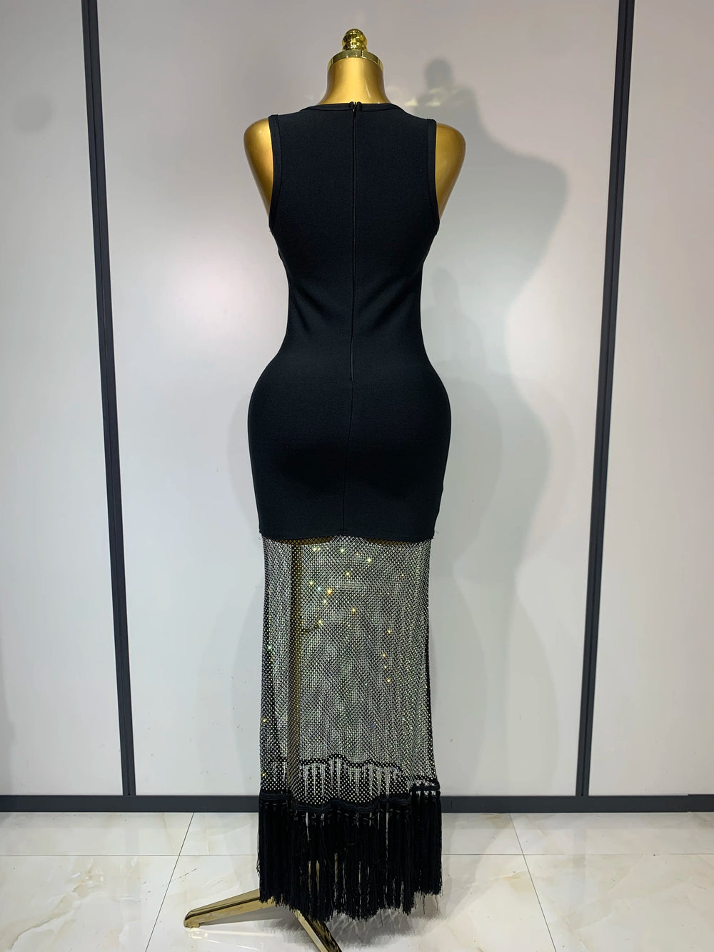 Black dress with a sequined bottom section on a mannequin against a white background