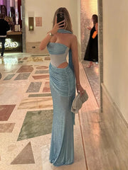 Woman in a blue evening gown taking a mirror selfie in an elegant interior setting.