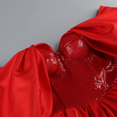 Close-up of a red dress with sequin details on a gray background