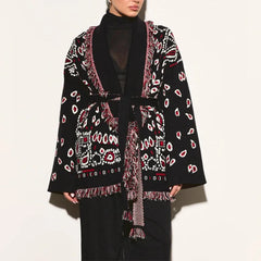 Black patterned cardigan worn by a person on a white background