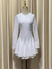 White dress on a mannequin against a beige curtain background