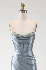 Silver evening gown on a mannequin with a plain background