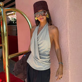 Model wearing a grey draped halter neck sleeveless knit top