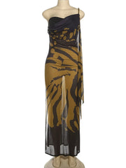 Mannequin wearing a black and gold patterned dress on a white background