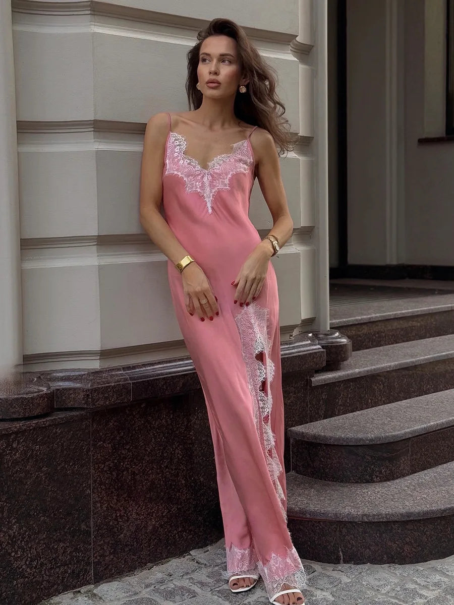 Woman wearing a pink lace nightgown standing on steps.