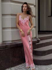 Woman wearing a pink lace nightgown standing on steps.
