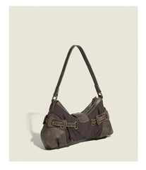 Brown handbag with leather straps on a beige background