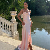 Woman in a pink dress standing by a lake with ducks