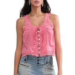 Woman wearing a pink lace top and denim shorts on a white background