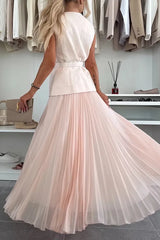 Woman wearing a white top and pink pleated skirt in a clothing store.