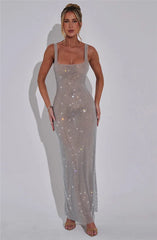 Woman wearing a sparkly silver dress against a white background