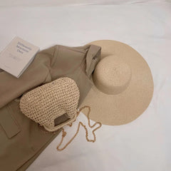 Beige straw hat and bag with a beige jacket on a white surface