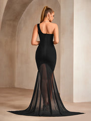 Woman wearing a black evening gown with a long train in an elegant setting.