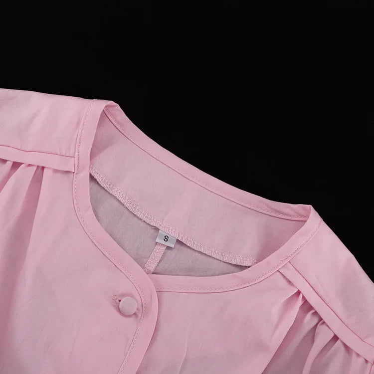 Close-up of a pink garment with a button on a black background