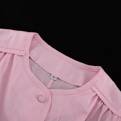 Close-up of a pink garment with a button on a black background
