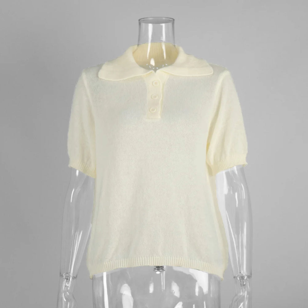 Mannequin wearing a light yellow short-sleeve sweater against a gray background