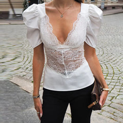 Person wearing a white lace top with puffed sleeves on a street.