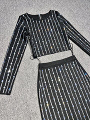 Black outfit with silver sequin details on a gray surface