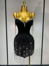 Black dress with silver embellishments on a mannequin against a neutral background