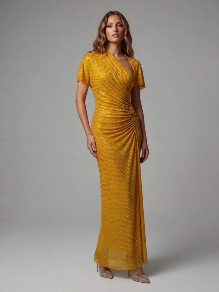 Woman wearing a gold evening gown against a grey background
