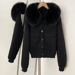 Black ribbed knit jacket with a large natural black fur collar.
