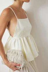 White dress with fringe details on a plain background