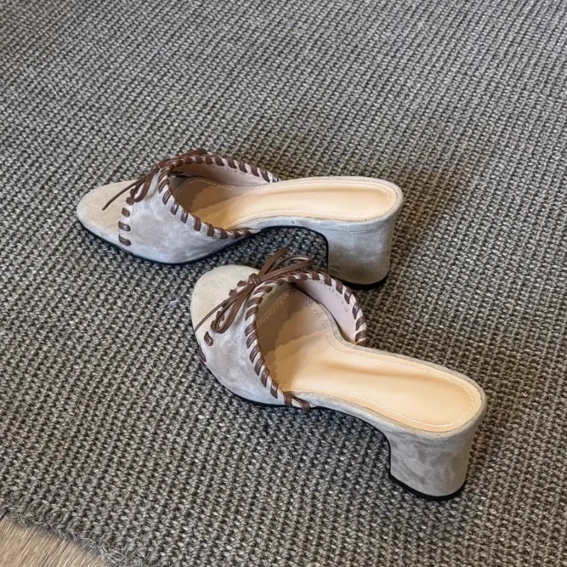 Light grey open toe square heel mules with stitched trim and bow detail