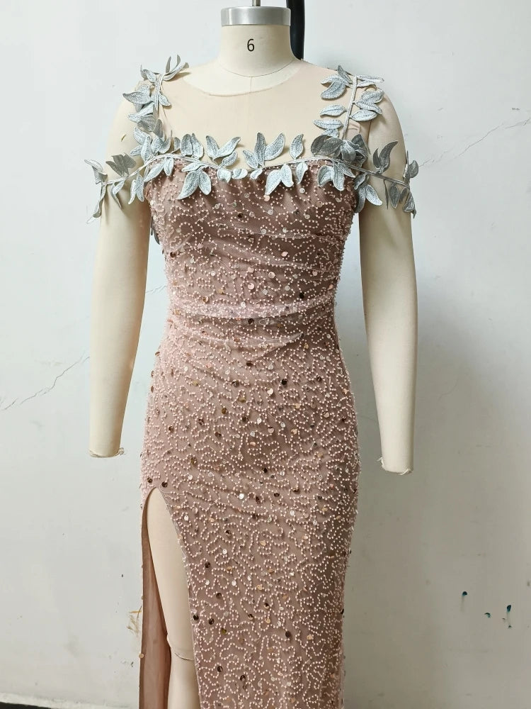 Rose gold evening gown with leaf embellishments on a mannequin against a white background