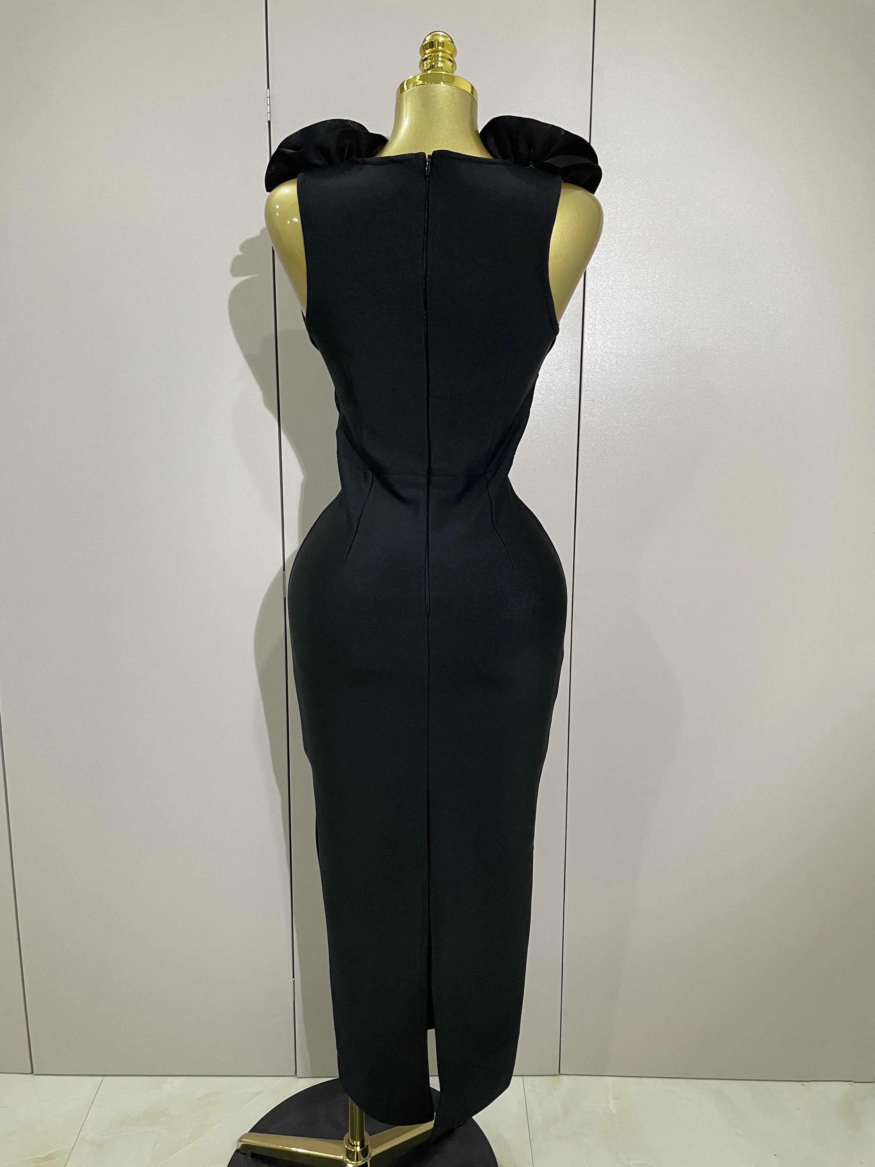 Black evening gown on a mannequin against a white background
