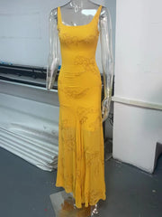 Yellow dress on a mannequin in an indoor setting with a white wall and gray floor.