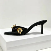 Black heeled mule with metal flower and crystal embellishments